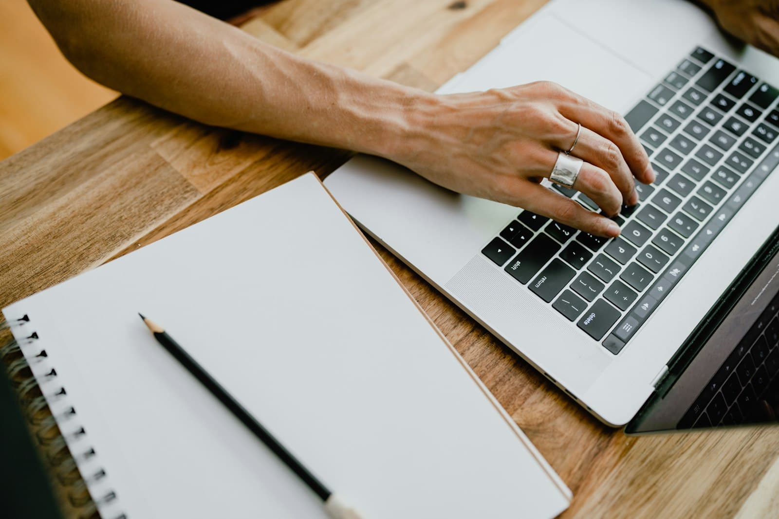 Typing a follow-up note on a laptop, the same small habit as logging a line in the tracking spreadsheet each day.