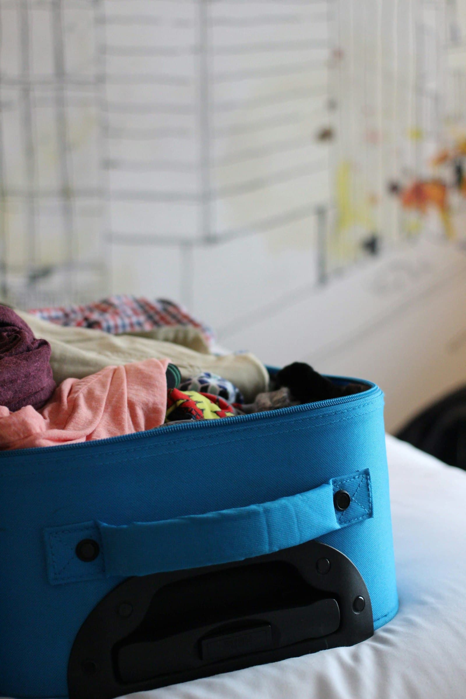 A packed suitcase with clothes ready to travel, the pre-travel packet a good onboarding system sends out automatically A packed suitcase with clothes ready to travel, the pre-travel packet a good onboarding system sends out automatically