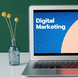 "Open laptop displaying 'Digital Marketing' on screen beside a decorative vase, representing online promotion strategies for travel agencies"